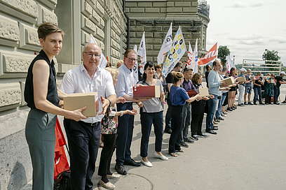 Una catena umana composta dai presidenti dei maggiori sindacati svizzeri consegna alla Cancelleria federale gli scatoloni di firme per il referendum contro la LPP 21.